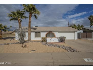 Single story home with desert landscaping, two palm trees, and a large driveway at 4102 E Blanche Dr, Phoenix, AZ 85032