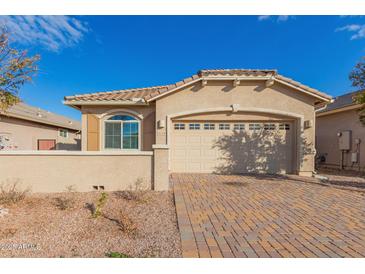 Tan single-story house with a two-car garage and a brick driveway at 4124 W Palace Station Rd, New River, AZ 85087