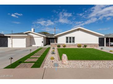 Newly renovated home with modern curb appeal and artificial turf at 6414 E Sheridan St, Scottsdale, AZ 85257