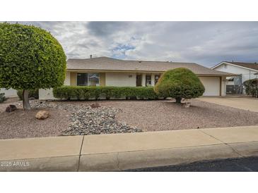 Single-story home with landscaped front yard, driveway, and neutral color scheme at 10027 W Concord Ave, Sun City, AZ 85351