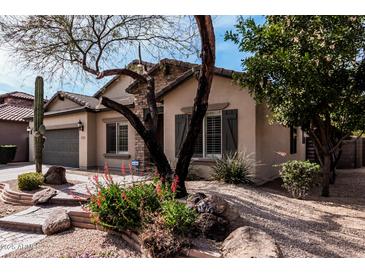 Attractive single-story home with lush desert landscaping, a stone-accented entrance, and a two-car garage at 21804 N 38Th Pl, Phoenix, AZ 85050