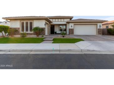 A charming single Gathering home featuring manicured lawn and brick-accented facade, offering a welcoming curb appeal at 2560 E Thornton Ct, Gilbert, AZ 85297