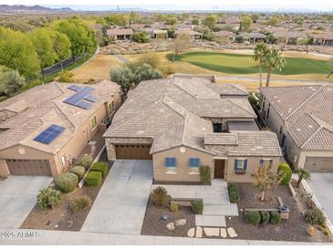 Aerial view of a house with solar panels and a golf course in the background at 27831 N Makena Pl, Peoria, AZ 85383