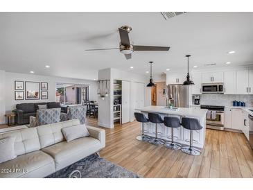 Open concept kitchen with white cabinets, island, and stainless steel appliances at 5201 E Winchcomb Dr, Scottsdale, AZ 85254