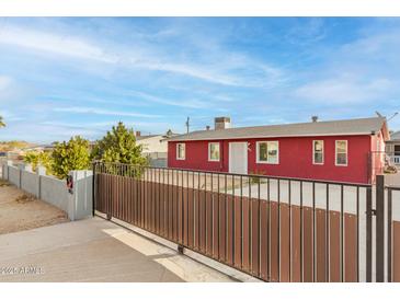 Red single story house with gated entrance at 8055 S 7Th St, Phoenix, AZ 85042