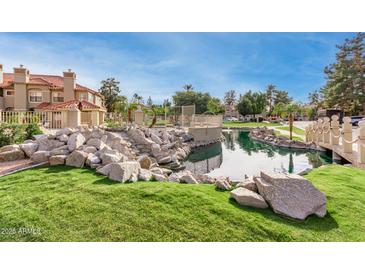 Serene community pond with a bridge and lush landscaping at 8270 N Hayden Rd # 1023, Scottsdale, AZ 85258