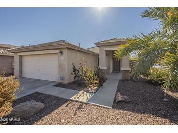 House exterior featuring a front yard, walkway, and attached garage at 11029 W Mountain View Dr, Avondale, AZ 85323