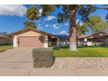 Single-story home with a two-car garage and mature landscaping at 12506 W Castle Rock Dr, Sun City West, AZ 85375