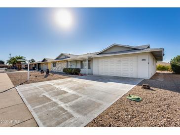 A charming single-story home features a spacious driveway and low maintenance desert landscaping at 13219 W Prospect Dr, Sun City West, AZ 85375