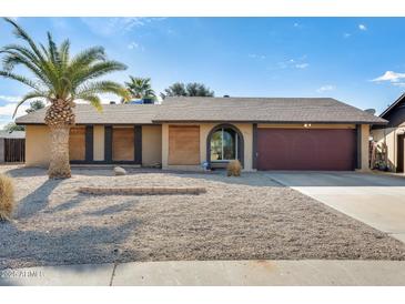 Single-story home with a red door and desert landscaping at 1437 W Yukon Dr, Phoenix, AZ 85027