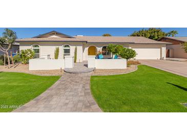 Updated mid-century modern home with landscaped lawn and walkway at 2032 E Pegasus Dr, Tempe, AZ 85283