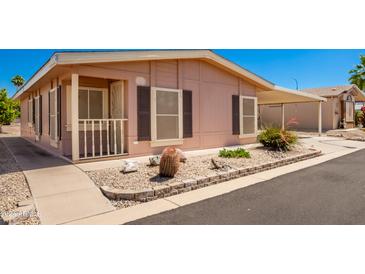 Tan single-wide manufactured home with carport and small front yard at 2400 E Baseline Ave # 84, Apache Junction, AZ 85119