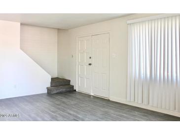 Bright entryway with gray flooring, staircase, and double doors at 4111 W Reade Ave, Phoenix, AZ 85019