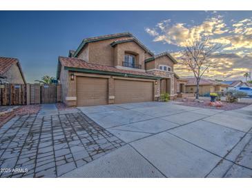 Two-story house with three-car garage and landscaped front yard at 15727 W Rimrock St, Surprise, AZ 85374