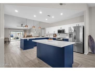 Spacious kitchen with island, stainless steel appliances, and white and blue cabinets at 17600 N 64Th Dr, Glendale, AZ 85308