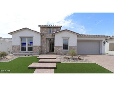 Beautiful single-story home featuring stone accents, manicured lawn and a spacious two car garage at 20233 W San Miguel Ave, Litchfield Park, AZ 85340