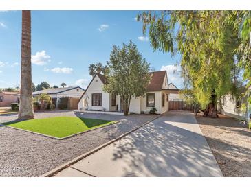 Charming, light-colored, single-story home with well-kept yard and long driveway at 2209 E Weldon Ave, Phoenix, AZ 85016