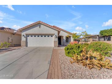 Single-story home with desert landscaping and a two-car garage at 22992 W Lasso Ln, Buckeye, AZ 85326