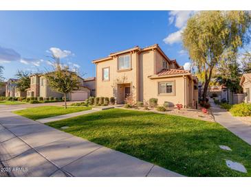 Two-story tan house with a landscaped lawn and walkway at 41705 N Globe Ct, Phoenix, AZ 85086