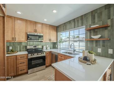 Modern kitchen features stainless steel appliances and wood cabinets at 4910 W Townley Ave # 4910, Glendale, AZ 85302