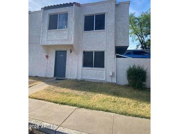 Two-story stucco condo with a gray door and small front yard at 5233 N 42Nd Dr, Phoenix, AZ 85019