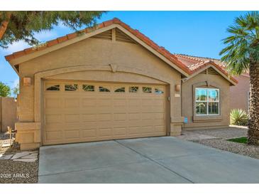 Tan two-story house with a two-car garage and desert landscaping at 8947 E Mescal St, Scottsdale, AZ 85260