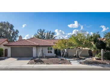 Single-story home with terracotta tile roof and desert landscaping at 9230 N 104Th Pl, Scottsdale, AZ 85258