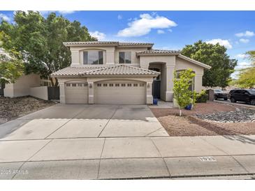 Elegant two-story home featuring a tile roof, three-car garage, and meticulously landscaped front yard at 1923 E Drake Dr, Tempe, AZ 85283