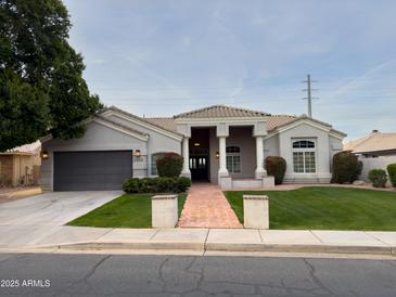 Single-story home with landscaped yard, driveway, and attached garage at 2332 E Nora St, Mesa, AZ 85213