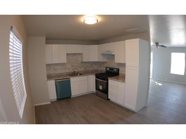 Bright kitchen with white cabinets, gray flooring, and teal appliances at 422 W Jamestown Rd, Kearny, AZ 85137