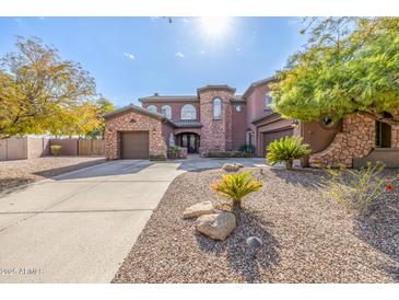 Stunning two-story home with stone accents and a three-car garage at 4543 S Roy Rogers Way, Gilbert, AZ 85297