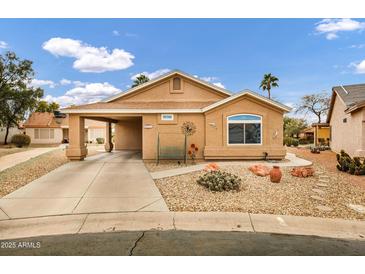 Tan one-story house with a covered carport and landscaped yard at 6892 S Lake Forest Ct, Chandler, AZ 85249