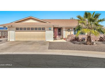 Tan brick ranch house with attached garage and desert landscaping at 10312 W Sierra Dawn Dr, Sun City, AZ 85351