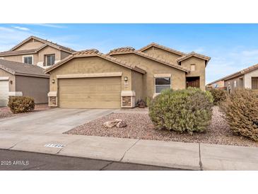 Tan two-story house with a two-car garage and well-maintained landscaping at 11608 W Oglesby Ave, Youngtown, AZ 85363