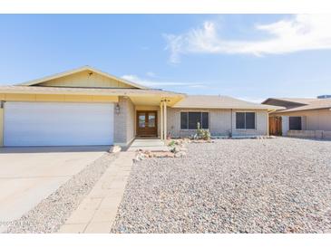 Charming single-story home featuring a desert landscape, brick accents, and a welcoming double-door entrance at 14019 N 51St Dr, Glendale, AZ 85306