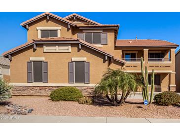 Two-story house with a large front yard, tan exterior, and a three-car garage at 17584 W Andora St, Surprise, AZ 85388