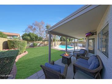 Relaxing backyard oasis with sparkling pool, covered patio, and fire pit at 18239 N 46Th St, Phoenix, AZ 85032