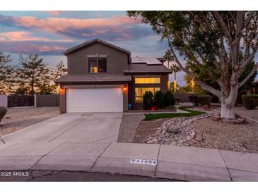 Two-story house with landscaped yard, driveway, and white garage door at dusk at 21054 N 74Th Ln, Glendale, AZ 85308