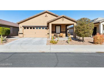 Tan house with a two-car garage and desert landscaping at 22402 W Harrison St, Buckeye, AZ 85326