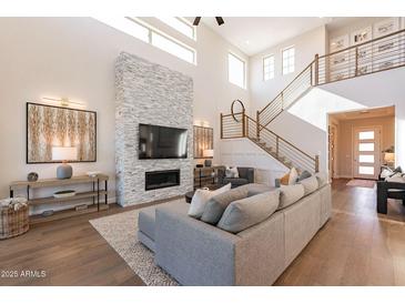 Spacious living room featuring a stone fireplace and high ceilings at 23071 N 98Th Dr, Peoria, AZ 85383