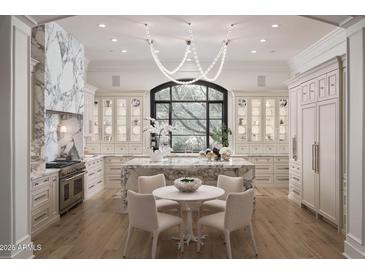 Elegant kitchen features marble counters, designer lighting and stainless steel appliances at 27545 N 97Th Pl, Scottsdale, AZ 85262