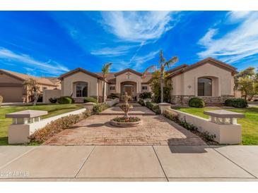 Stunning home featuring an inviting entrance, mature palms, stone accents, and lush landscaping at 2939 E Huber St, Mesa, AZ 85213