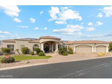 Elegant stucco home featuring a circular driveway, grand entrance with columns, and a three-car garage at 402 E Windmere Dr, Phoenix, AZ 85048