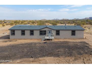 Single-story home with neutral exterior and deck at 645 S Warren Rd, Maricopa, AZ 85139