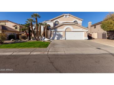 Two-story house with a large driveway and palm trees at 6970 W Morning Dove Dr, Glendale, AZ 85308