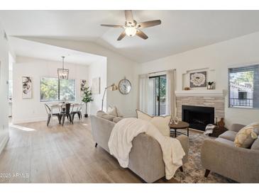 Bright living room with fireplace, hardwood floors, and comfy seating at 15050 N Thompson Peak Pkwy # 2033, Scottsdale, AZ 85260