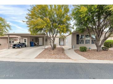 Tan colored manufactured home with carport and golf cart at 3301 S Goldfield Rd # 1015, Apache Junction, AZ 85119