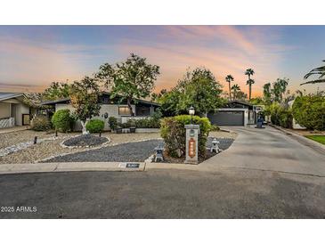 Beautiful mid-century modern home with landscaped front yard and long driveway at 5301 E Mitchell Dr, Phoenix, AZ 85018