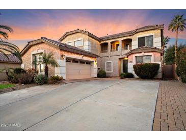 Two-story house with a three-car garage and landscaped front yard at 10730 E Medina Ave, Mesa, AZ 85209