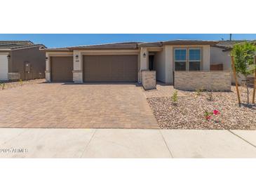 Charming single-story home with a three-car garage and brick paved driveway at 18225 W Hess St, Goodyear, AZ 85338